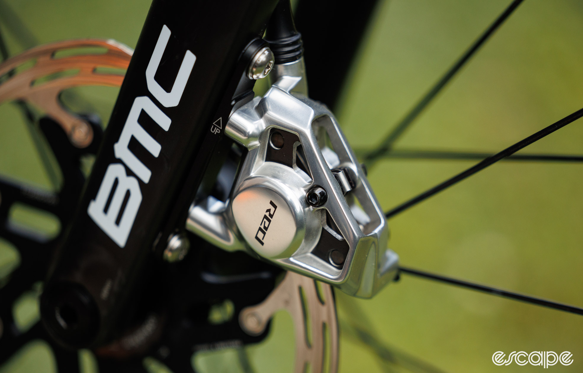 A close up of the SRAM Red AXS brake caliper. It's silver and with cut-away material. 