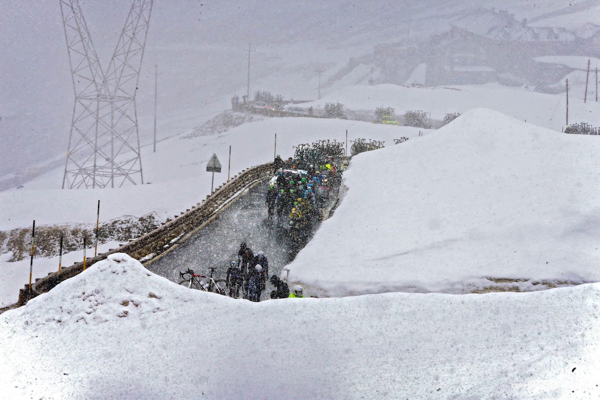 A snowy, rainy mountaintop scene with riders navigating woeful conditions in the high mountains.