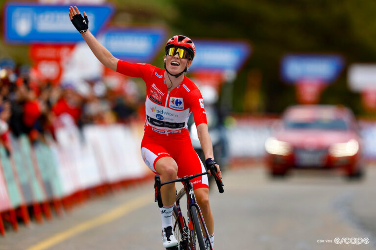 Demi Vollering in the red skinsuit of race leader celebrates stage 8 victory at the Vuelta España Feminina.