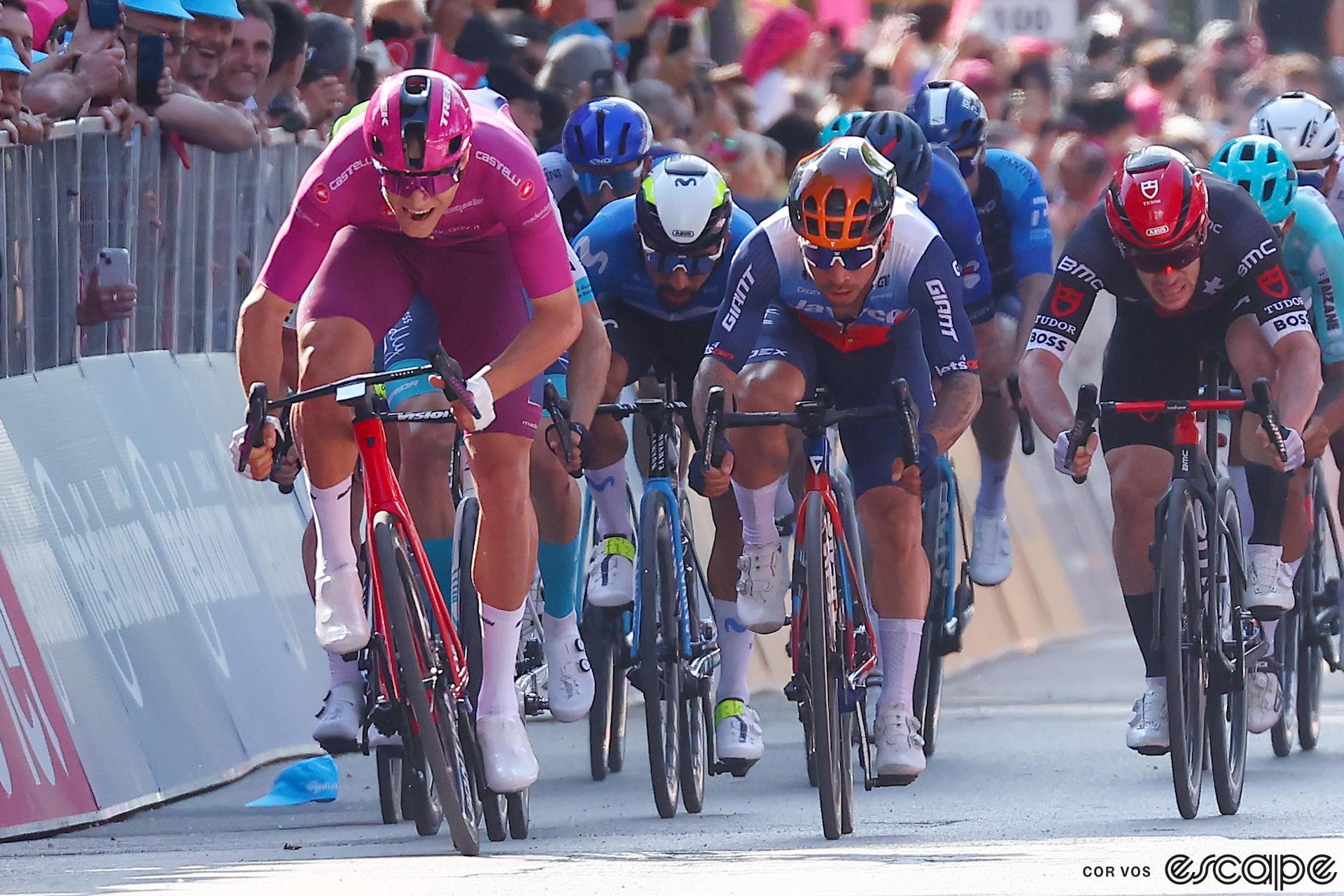 Jonathan Milan, in the fuschia jersey and shorts of the Giro d'Italia's points leader, charges toward the finish line on stage 5 of the race.