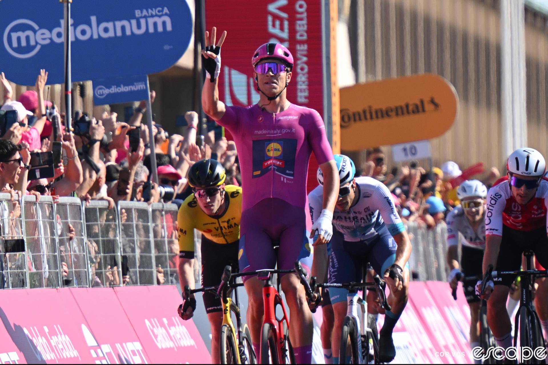 Jonathan Milan holds up three fingers in his right hand to signal his third stage win of the 2024 Giro d'Italia.
