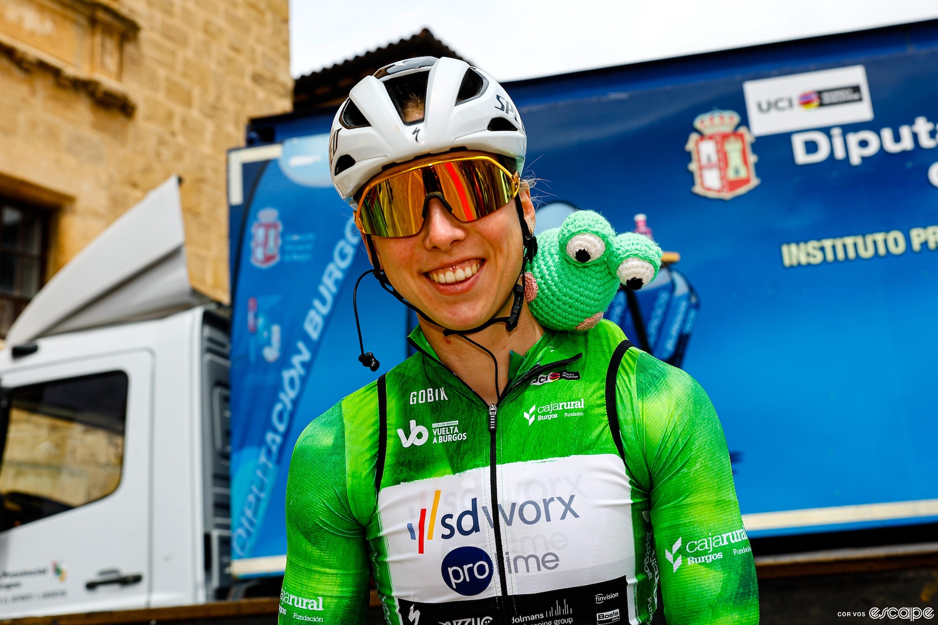 Lorena Wiebes poses for the camera with a crocheted frog on her shoulder. 