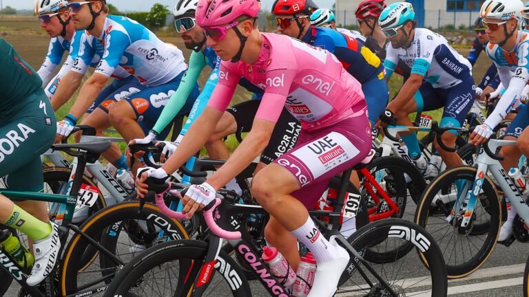Tadej Pogačar rides the Giro d'Italia in a race suit with a pink top of the overall leader and maroon shorts to honor the 75th anniversary of the Superga air disaster.