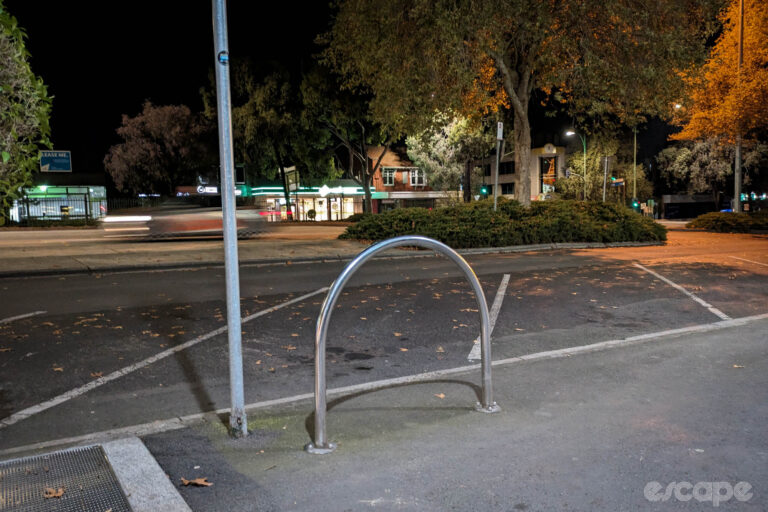 An empty bike rack at night.