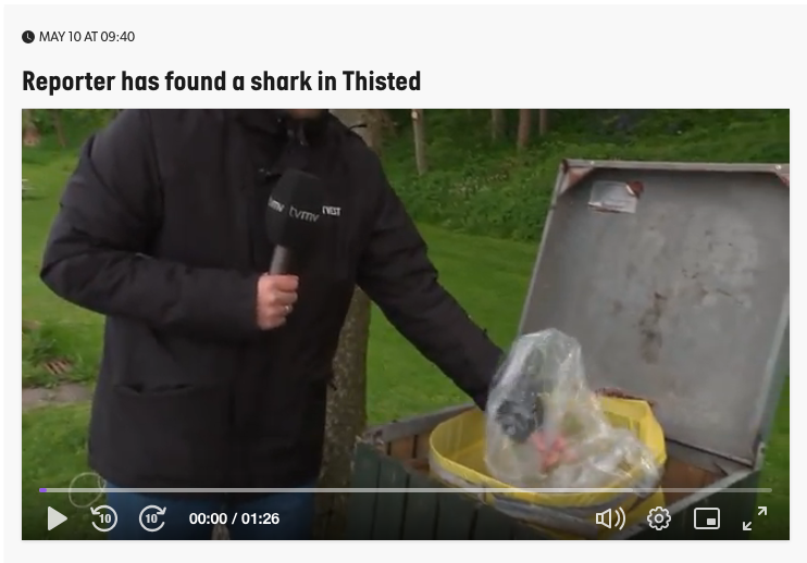 Screenshot: a reporter pulling a bag out of a bin