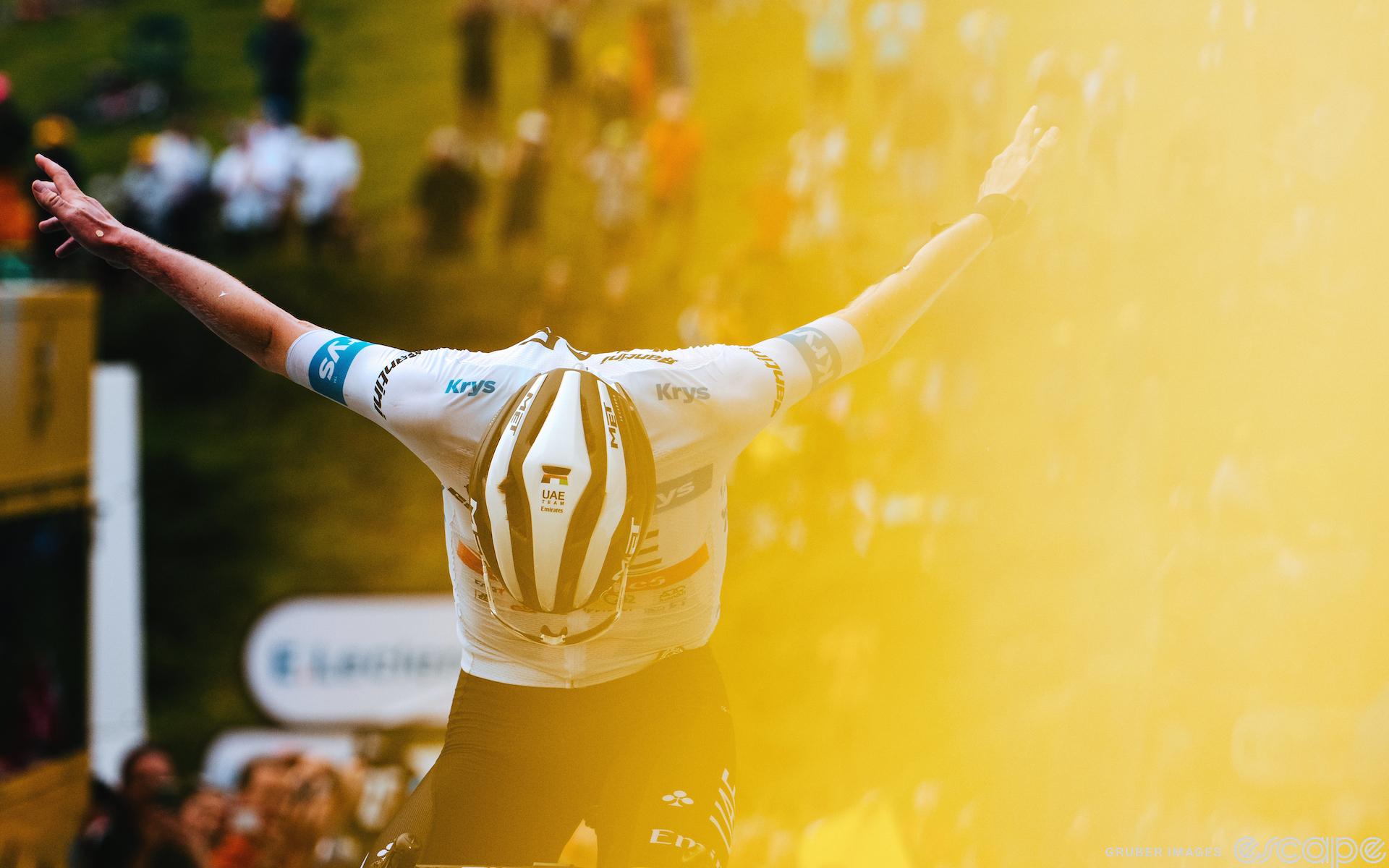 Tadej Pogačar bows theatrically as he crosses the line to win stage 6 of the 2023 Tour de France. The shot is filmed on the right half with a yellow haze, as if to suggest a yellow jersey.