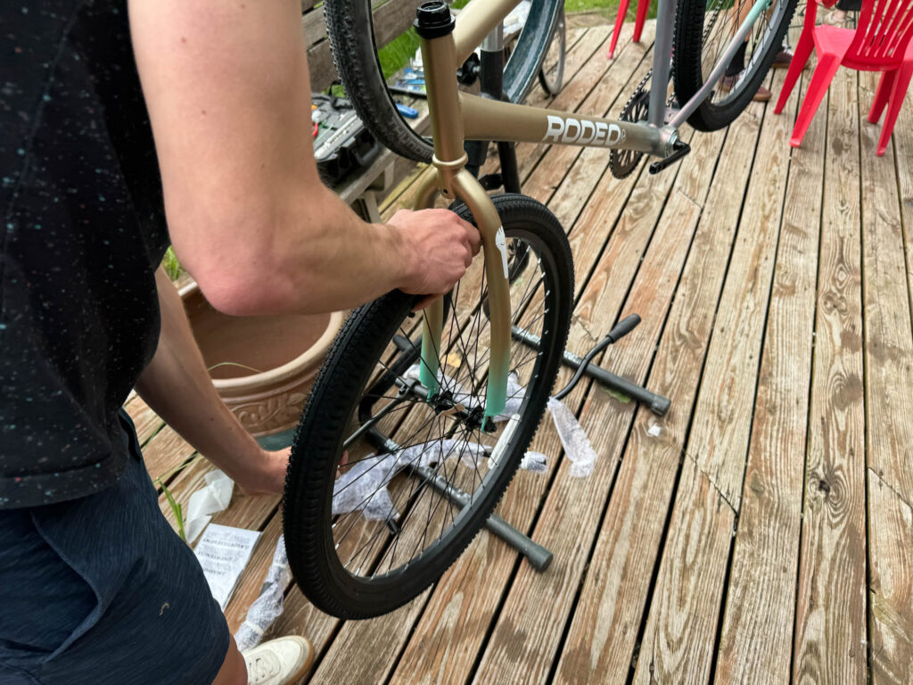 A wheel is installed in a spraypainted bike. 