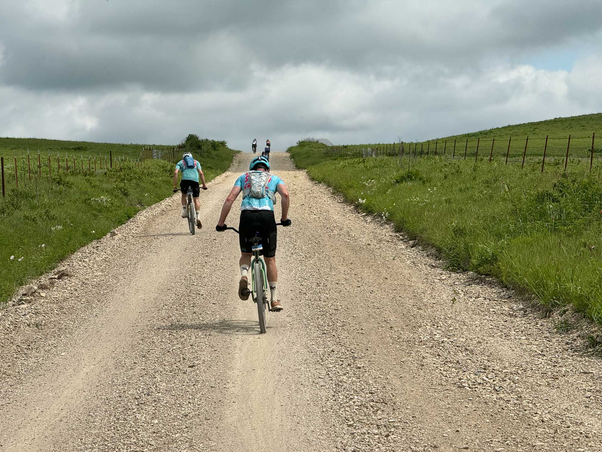 Nick and David ride out of the saddle up a steep gravel hill.