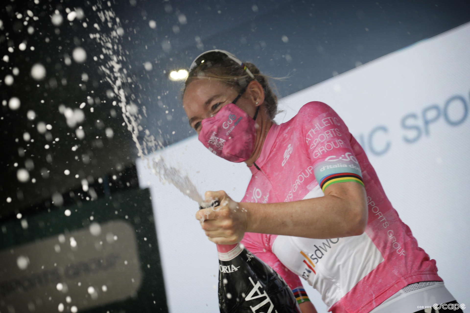 Van der Breggen sprays champagne while wearing the pink leader's jersey of the Giro Donne