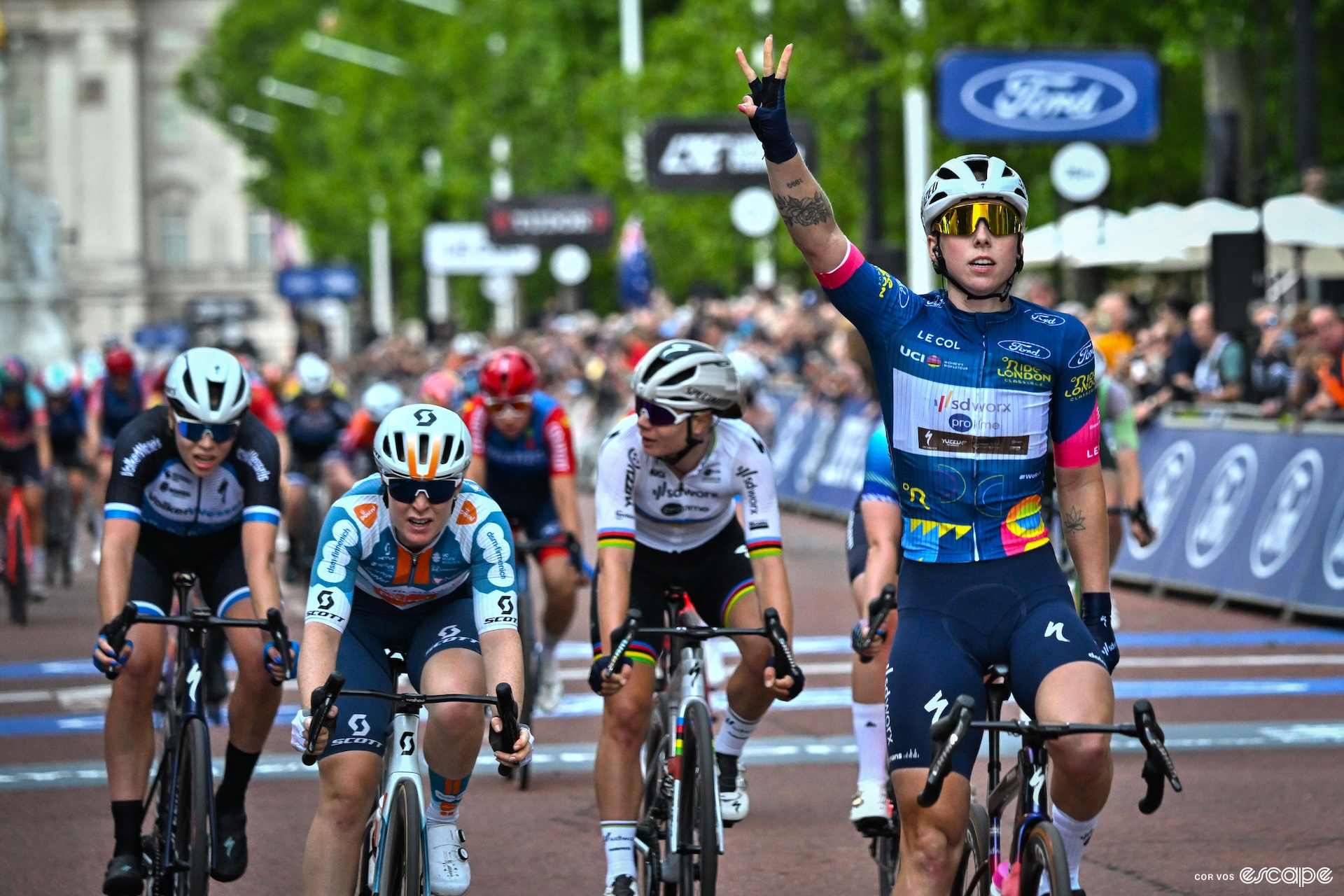 Lorena Wiebes raises her hand in a three after winning the final stage of RideLondon this year