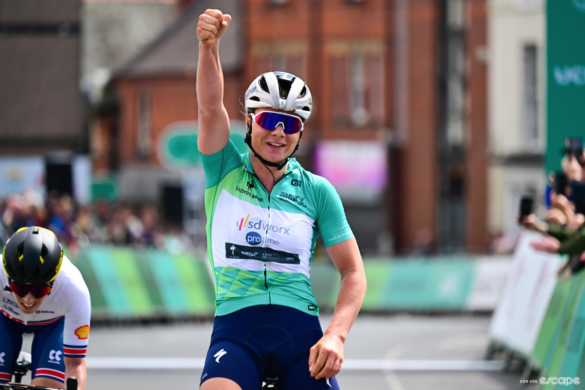 Kopecky raises one arm in victory, wearing the Tour of Britain leader's jersey.