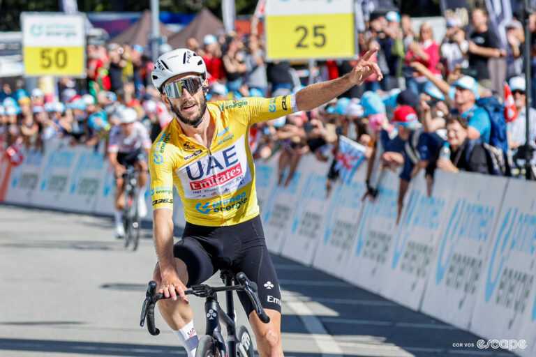 Adam Yates celebrates winning stage 5 of the 2024 Tour de Suisse wearing the yellow jersey.