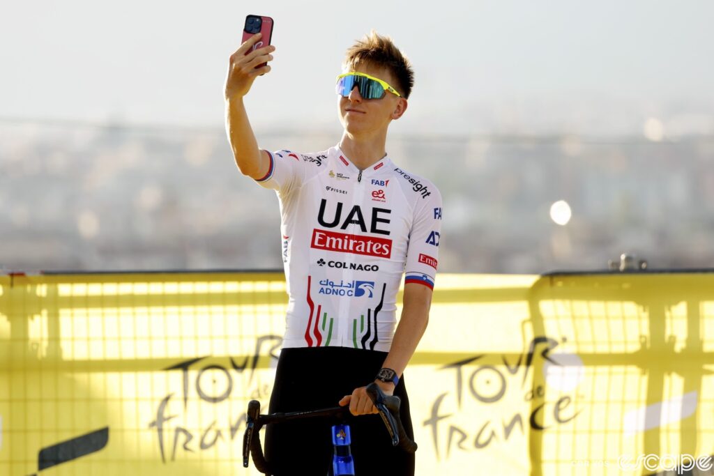 Tadej Pogačar takes a selfie during the teams presentation for the 2024 Tour de France.