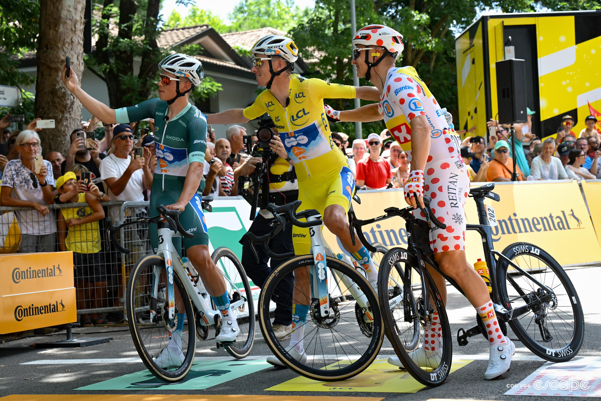 Frank van den Broek, Romain Bardet and Jonas Abrahamsen wearing the green, yellow and polkadot jerseys respectively at the start of the stage 2 of the 2024 Tour de France.