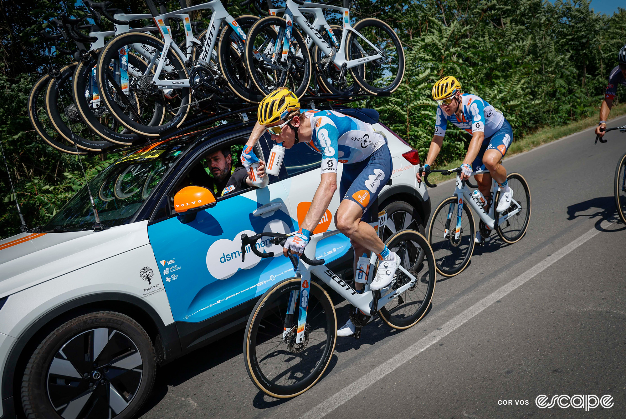 DSM Firmenich-PostNL receive bottles from their team car on the Tour's stage 2.