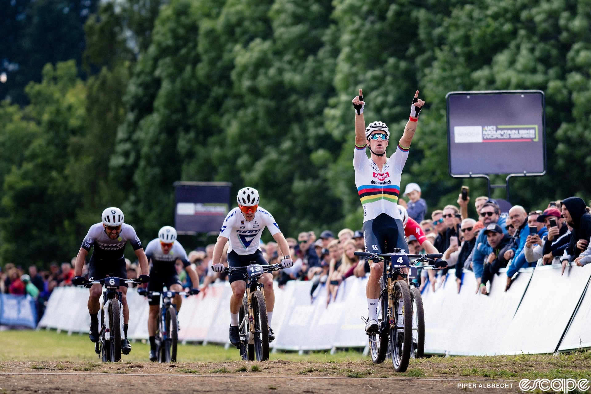 Sam Gaze punches both hands in the air with index fingers up as he outsprints a small group to win the XCC at the Val di Sole Mountain Bike World Cup.