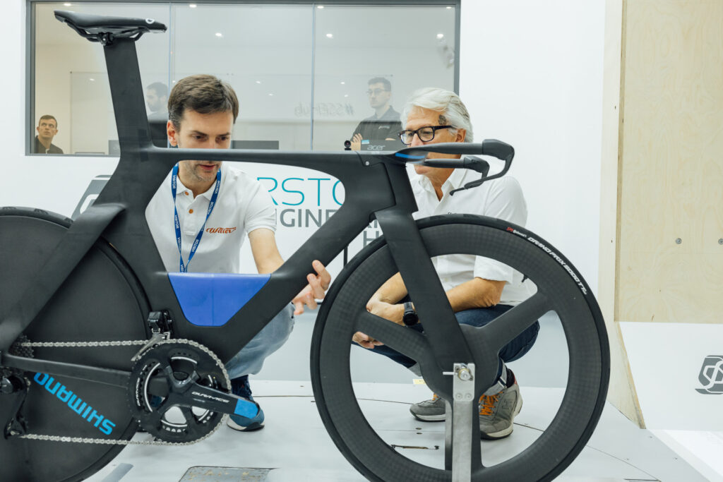 The image shows Marco Genovese (Head of Design) and Claudio Salomoni (Innovation Lab specialist) working on the prototype bike in Silverstone wind tunnel.