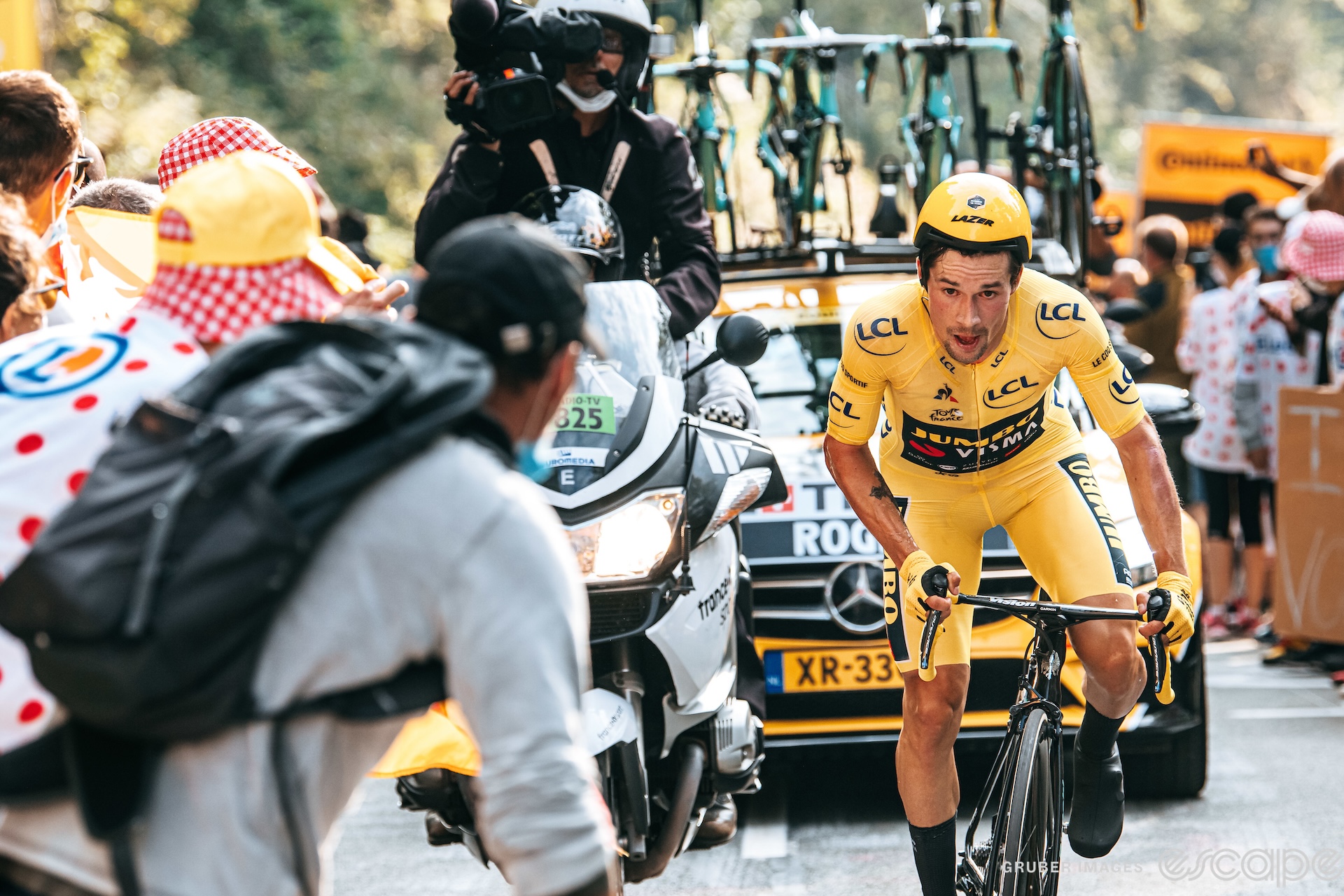 Primož Roglič climbs in the final time trial of the 2020 Tour de France. He has a distant expression on his flushed face, as if he knows the yellow jersey he wears is no longer his.