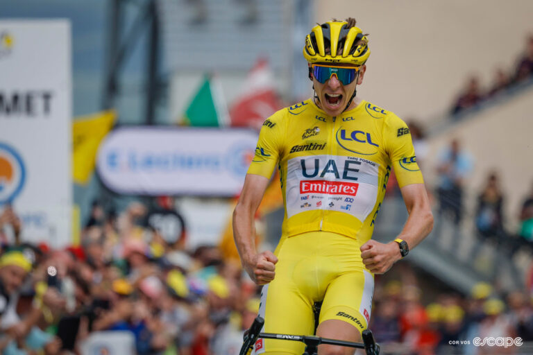 Tadej Pogačar in yellow skinsuit and helmet, roars as he wins stage 14 of the 2024 Tour de France.