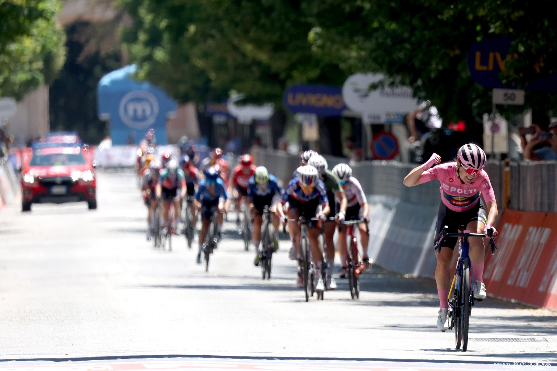 Elisa throws her fist in the air as she crosses the finish line