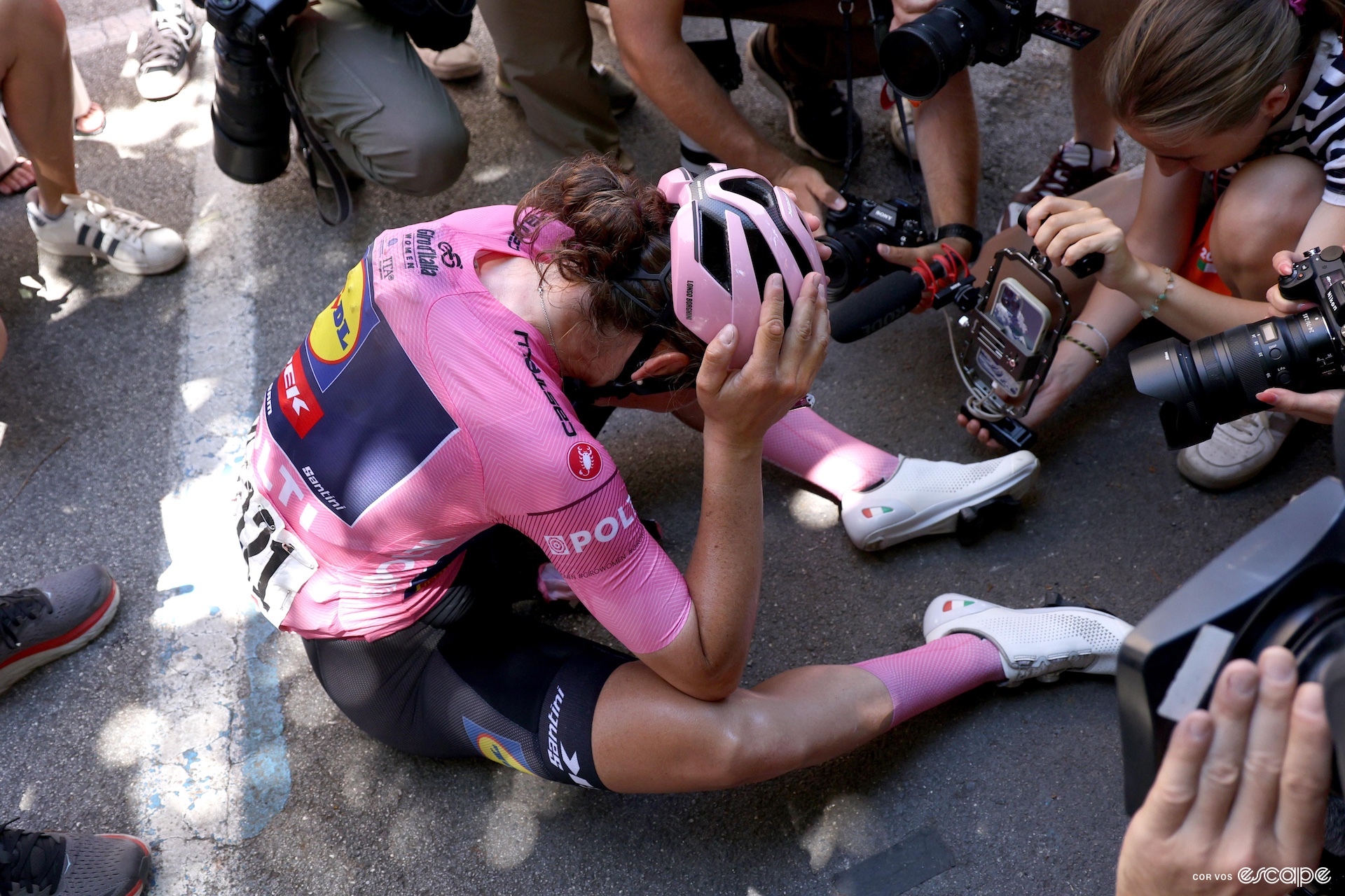 Longo Borghini sitting on the ground, holding her head in her hands