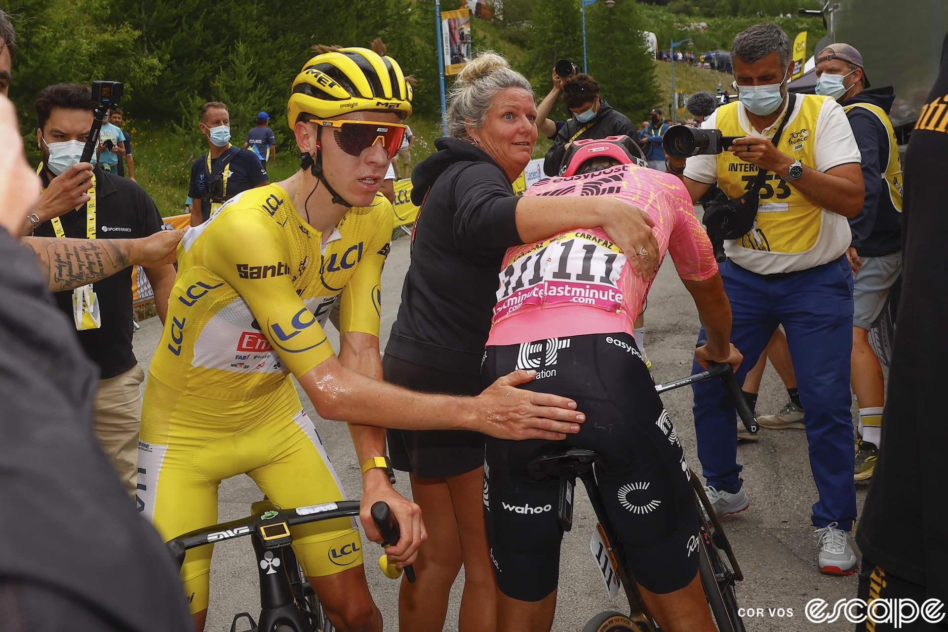 Tadej Pogačar pats Richard Carapaz on the butt after stage 19 of the 2024 Tour. The EF Education rider is slumped over his handlebars as a soigneur shepherds him away from the line after his unsuccessful breakaway attempt.