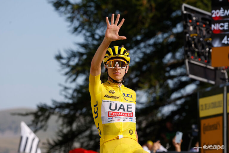 Tadej Pogačar in the yellow jersey shows a widespreda hand in celebration of his fifth stage win at the 2024 Tour de France.