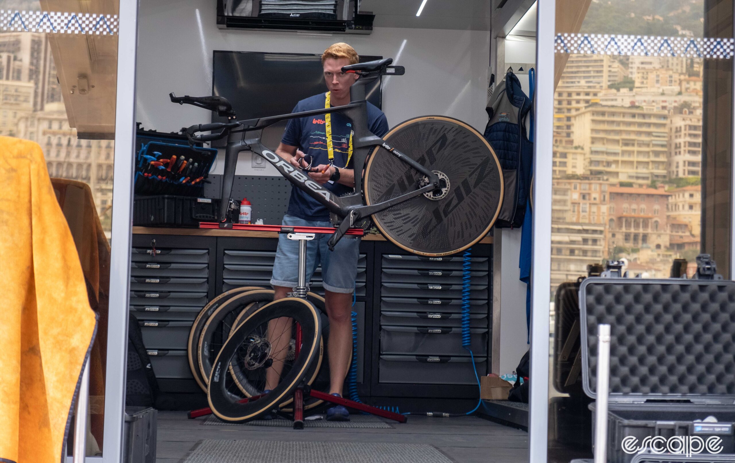 The image shows a team mechanic working on an Orbea Ordu inside the mechanics truck. 