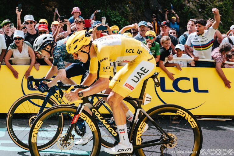 Jonas Vingegaard and Tadej Pogačar sprint for the line on stage 11 of the 2024 Tour de France. They're seen from the side, with Jonas to Tadej's right, and edging slightly ahead of the yellow jersey for the win.