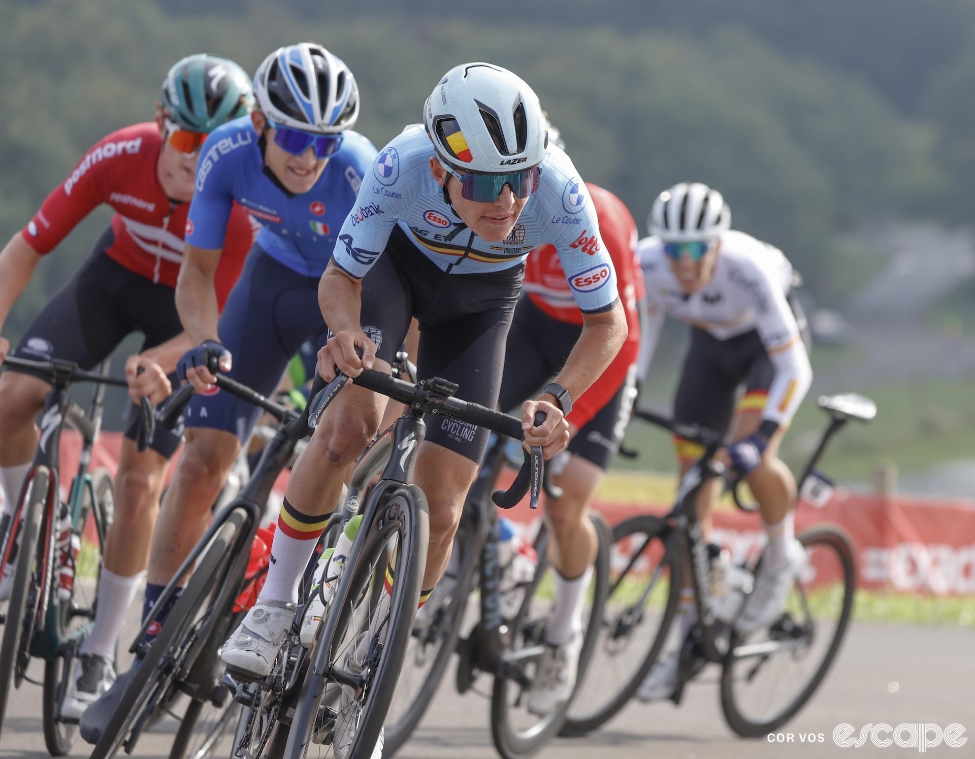 Jarno Widar, in Belgian national-team kit, attacks at the European Junior Road Championships. He's out of the saddle through a switchback, with riders from Italy, Denmark, the Netherlands, and Spain on his wheel.