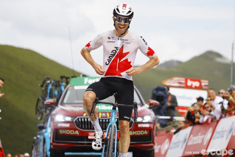 Michael Woods points to the maple-leaf logo on his Canadian national champion's jersey as he crosses the line to win stage 13 of the 2024 Vuelta a España.